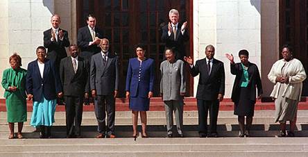 The Little Rock Nine stand and wave to a crowd.